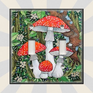 May include: A light switch cover featuring a whimsical illustration of red and white mushrooms growing in a lush green forest setting.