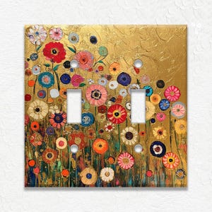 May include: A decorative double light switch cover featuring a colorful floral design. The artwork showcases a field of vibrant flowers in shades of red, pink, blue, and yellow against a textured gold background. The cover has two switch openings.
