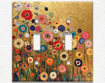 May include: A decorative double light switch cover featuring a colorful floral design. The artwork showcases a field of vibrant flowers in shades of red, pink, blue, and yellow against a textured gold background. The cover has two switch openings.