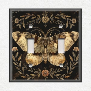 May include: A light switch cover featuring a detailed illustration of a butterfly with brown and white wings against a black background with gold floral accents.