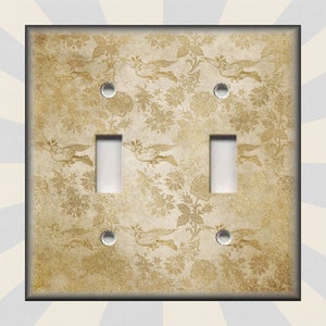 May include: A light brown double light switch cover with a vintage floral pattern and two white toggle switches.
