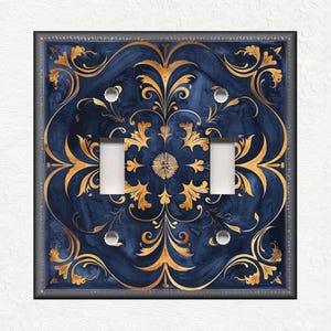 May include: A decorative light switch cover with a blue and gold design. The design features a repeating pattern of stylized floral motifs.