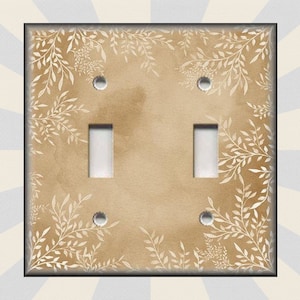 May include: A light brown light switch cover with a white floral pattern. The switch cover has two toggle switches.