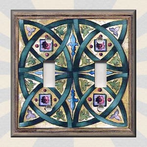 May include: A light switch cover with a decorative design featuring a Celtic knot pattern in shades of green, blue, and brown. The design is on a cream background.