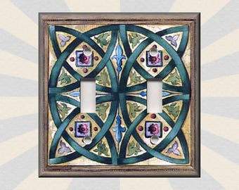 May include: A light switch cover with a decorative design featuring a Celtic knot pattern in shades of green, blue, and brown. The design is on a cream background.