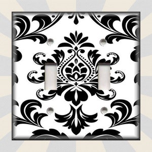 May include: Black and white damask pattern light switch cover plate. The pattern is a traditional damask design with a repeating motif of stylized leaves and flowers.