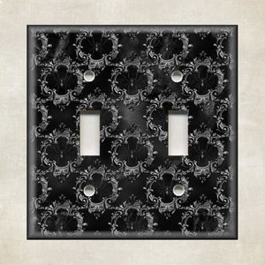 May include: A black and white light switch cover with a damask pattern and spider web design.