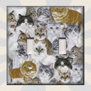 May include: A light switch cover featuring a collage of various cats in different poses and colors. The cats are arranged in a random pattern, creating a playful and whimsical design.