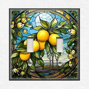 May include: A stained glass style light switch cover featuring a lemon tree with yellow lemons and green leaves. The background is a blue sky with a white sun.