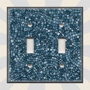 May include: A light blue and dark blue mosaic pattern light switch cover with a swirling design.
