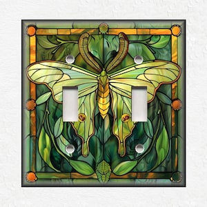 May include: A light switch cover featuring a stained glass butterfly design with green, yellow, and brown colors.