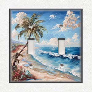 May include: A double light switch cover with a tropical beach scene. The image features a palm tree on a sandy beach with blue ocean waves and a bright blue sky with white clouds.