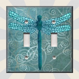 May include: A light blue dragonfly with a teal body and wings against a teal background with a swirling pattern. The dragonfly is centered on a light switch plate with two toggle switches.