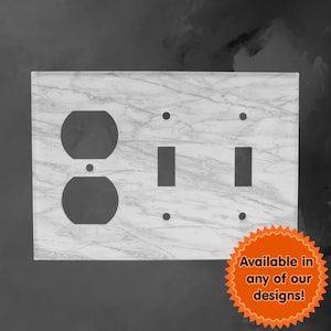May include: A white marble-patterned electrical outlet and light switch cover plate. The plate has two light switches and one double outlet. The text "Available in any of our designs!" is on a starburst sticker in the lower right corner.
