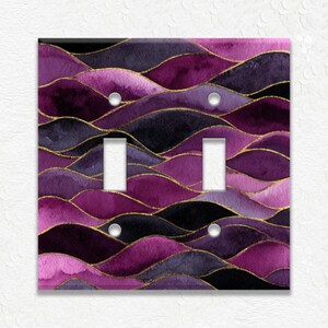 May include: A decorative double light switch cover featuring a watercolor design of layered purple, black, and gold wavy lines. The cover has two switch openings and two screw holes.