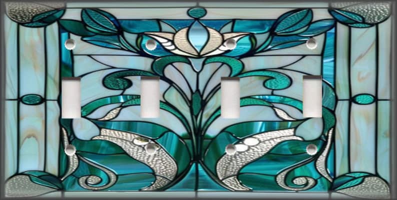 May include: A decorative light switch cover with a stained glass design. The cover features a floral pattern in shades of teal, white, and silver. It has four light switch openings and a rectangular shape.