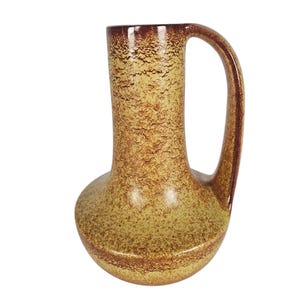 Peut inclure: Pichet en céramique vintage avec une surface texturée et mouchetée dans des tons bruns et beiges. Le pichet a une base arrondie, un long col et une anse incurvée. Le bord et la anse sont brun foncé.