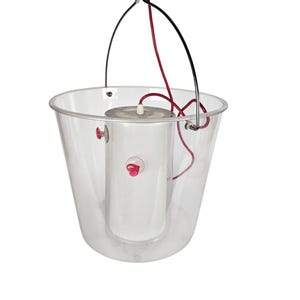 May include: A clear plastic bucket with a silver handle and a white cylindrical object inside. The object has a red knob and a red cord attached to it.