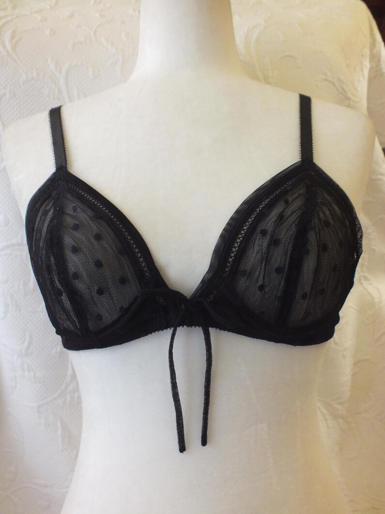 May include: Black lace bra with polka dots and a tie detail in the front.
