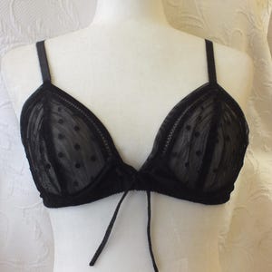 May include: Black lace bra with polka dots and a tie detail in the front.