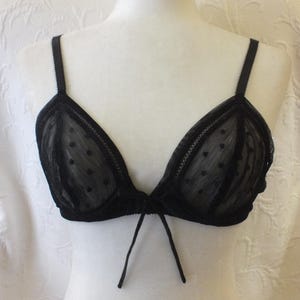 May include: Black lace bra with polka dots and a tie at the center.