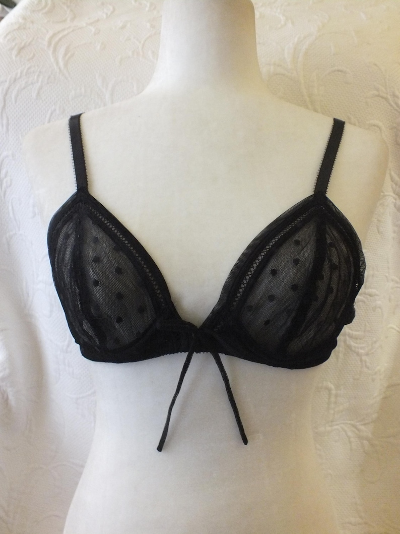 May include: Black lace bra with polka dots and a tie at the center.