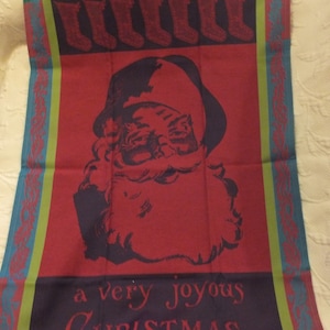 Puede incluir: Una tela roja con temática navideña con una ilustración de Papá Noel y el texto "a very joyous CHRISTMAS". La tela tiene un borde con detalles turquesa y verde, y una fila de calcetines en la parte superior.