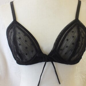 May include: Black lace bra with polka dots and a tie detail at the center.