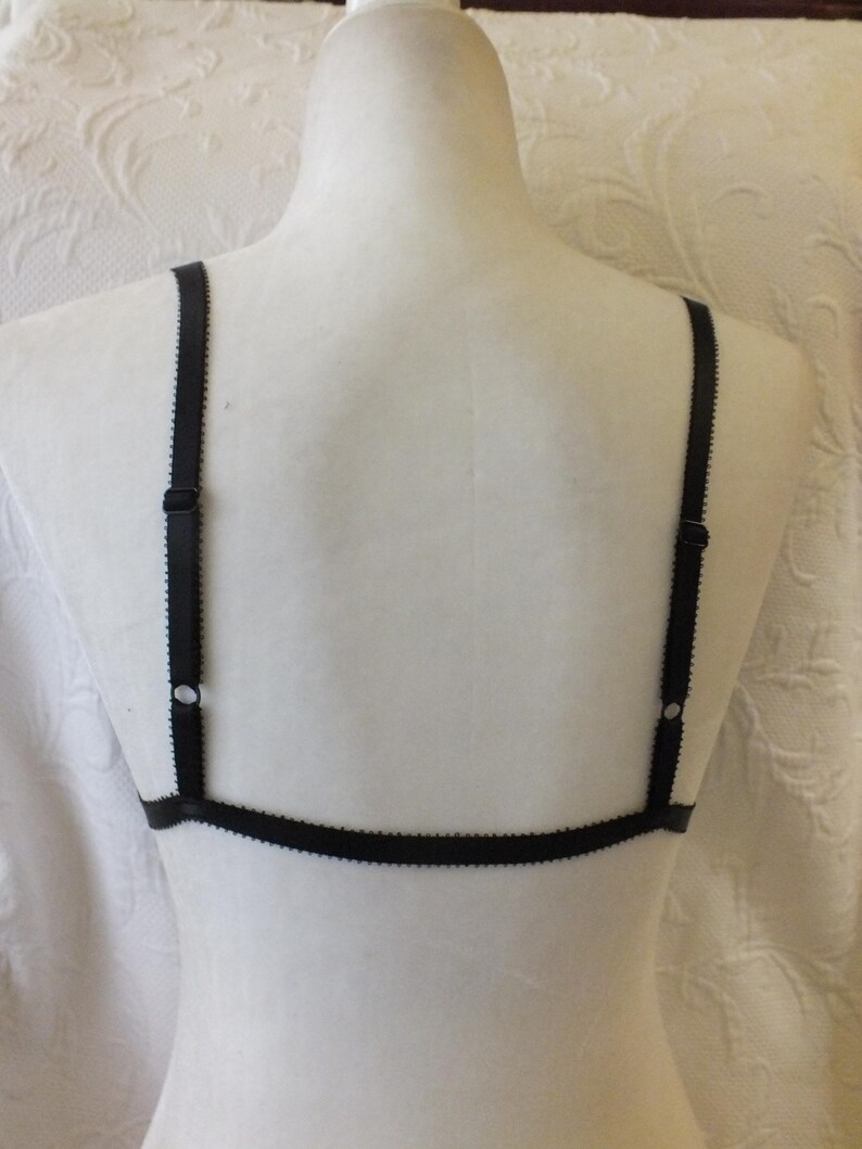 May include: Black lingerie bra with adjustable straps. The bra has a simple design with a thin band and straps.