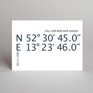 Könnte beinhalten: Eine weiße Karte mit dem Text "FALL DER BERLINER MAUER" und den Koordinaten: N 52°30′45.0" E 13°23′46.0" und dem Datum 09.11.1989.