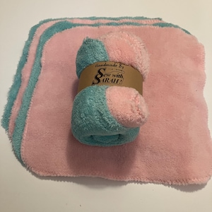 May include: Set of five pink and teal dishcloths with a brown tag that reads "Handmade By Sew with SARAH!"