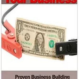 May include: A book titled "Jumpstart Your Business" with a red and black cover featuring a dollar bill connected to a battery cable. The book's subtitle is "Proven Business Building Techniques and Strategies" by Sarah J. Doyle.