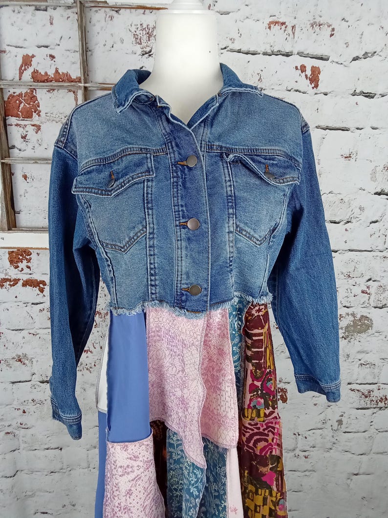 Blue denim and jean jacket buttoned up on a mannequin. Pink and blue fabric sewn to the bottom shown