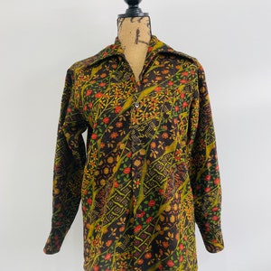 May include: A long-sleeved button-up shirt with a brown, green, orange and red floral pattern.