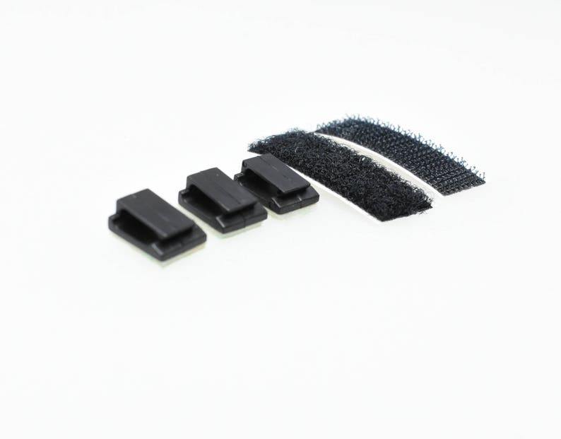May include: Four black adhesive cable clips with a white adhesive backing and two strips of black hook and loop fastener.