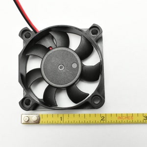 May include: A black computer fan with seven blades, measuring 1 inch in diameter, with red and black wires attached.