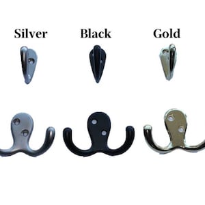 May include: Three double hooks in silver, black, and gold finishes. Each hook has two prongs.