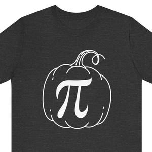 May include: A dark heather grey t-shirt with a white outline of a pumpkin with the mathematical symbol pi inside.