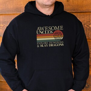 May include: Black hooded sweatshirt with a vintage-style graphic that says "Awesome Uncles Explore Dungeons & Slay Dragons" with a retro-style dice graphic.