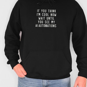 Könnte beinhalten: Schwarzer Kapuzenpullover mit dem Text "If you think I'm cool now wait until you see my AI automations" in weiß gedruckt.