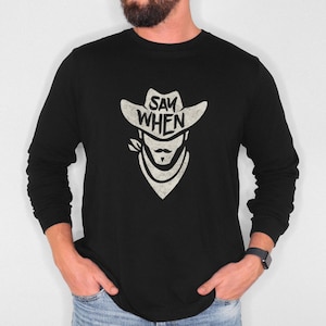 Puede incluir: Camiseta negra de manga larga con un gráfico blanco de un vaquero con un sombrero que dice "Say When".