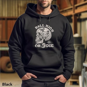 Puede incluir: Sudadera con capucha negra con un gráfico de calavera blanca y el texto "Roll High or Die".