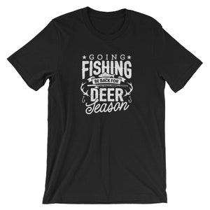 Puede incluir: Camiseta negra con texto blanco que dice "Going Fishing Be Back For Deer Season". El texto está estilizado con un anzuelo de pesca y un gráfico de pescado.