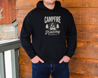 May include: A black hoodie with a white graphic design that says "Campfire Drinking Society" with a campfire and pine trees.
