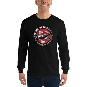 May include: Black long-sleeved t-shirt with a red circle graphic featuring a vintage aeroplane and the text "Lao Che Air Freight Nang Tao Airport Shanghai".