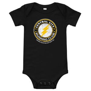 May include: Black baby growsuit with a yellow circle logo that says "Central City Running Club" with a lightning bolt inside the circle. The text below the circle says "Running faster than light since 1940."