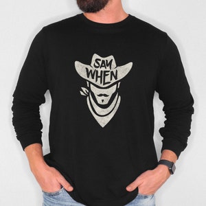 Puede incluir: Camiseta negra de manga larga con un gráfico blanco de un vaquero con un sombrero con el texto "SAY WHEN" en él.