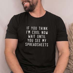 May include: Black t-shirt with white text that reads "If you think I'm cool now wait until you see my spreadsheets."