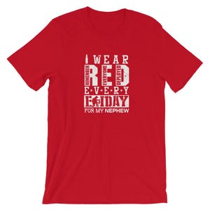 Könnte beinhalten: Rotes T-Shirt mit weißem Text, der "Ich trage jeden Tag Rot für meinen Neffen" lautet. Der Text ist so gestaltet, dass er wie eine Soldatenuniform aussieht.