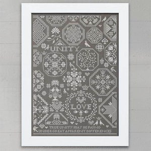 May include: A framed cross-stitch design with a gray background and white stitching. The design features a variety of geometric shapes and patterns, including hearts, stars, and flowers. The text "UNITY" and "LOVE" are stitched in the center of the design. The text "TRUE UNITY MAY BE FOUND UNDER GREAT APPARENT DIFFERENCES" is stitched at the bottom of the design.